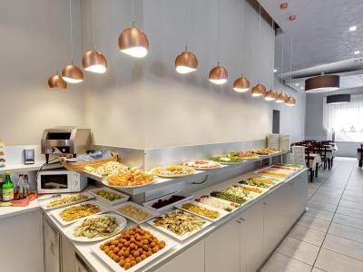 Buffet con piatti vari in un ristorante luminoso e moderno.