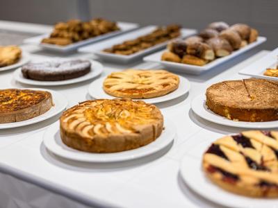 Un buffet di dolci deliziosi, torte e pasticcini invitanti su piatti bianchi.