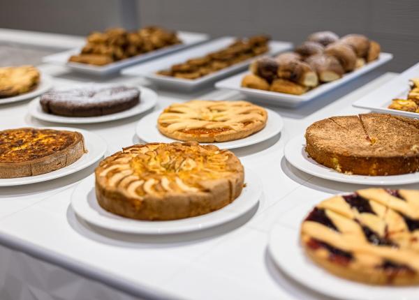 Un buffet di dolci deliziosi, torte e pasticcini invitanti su piatti bianchi.