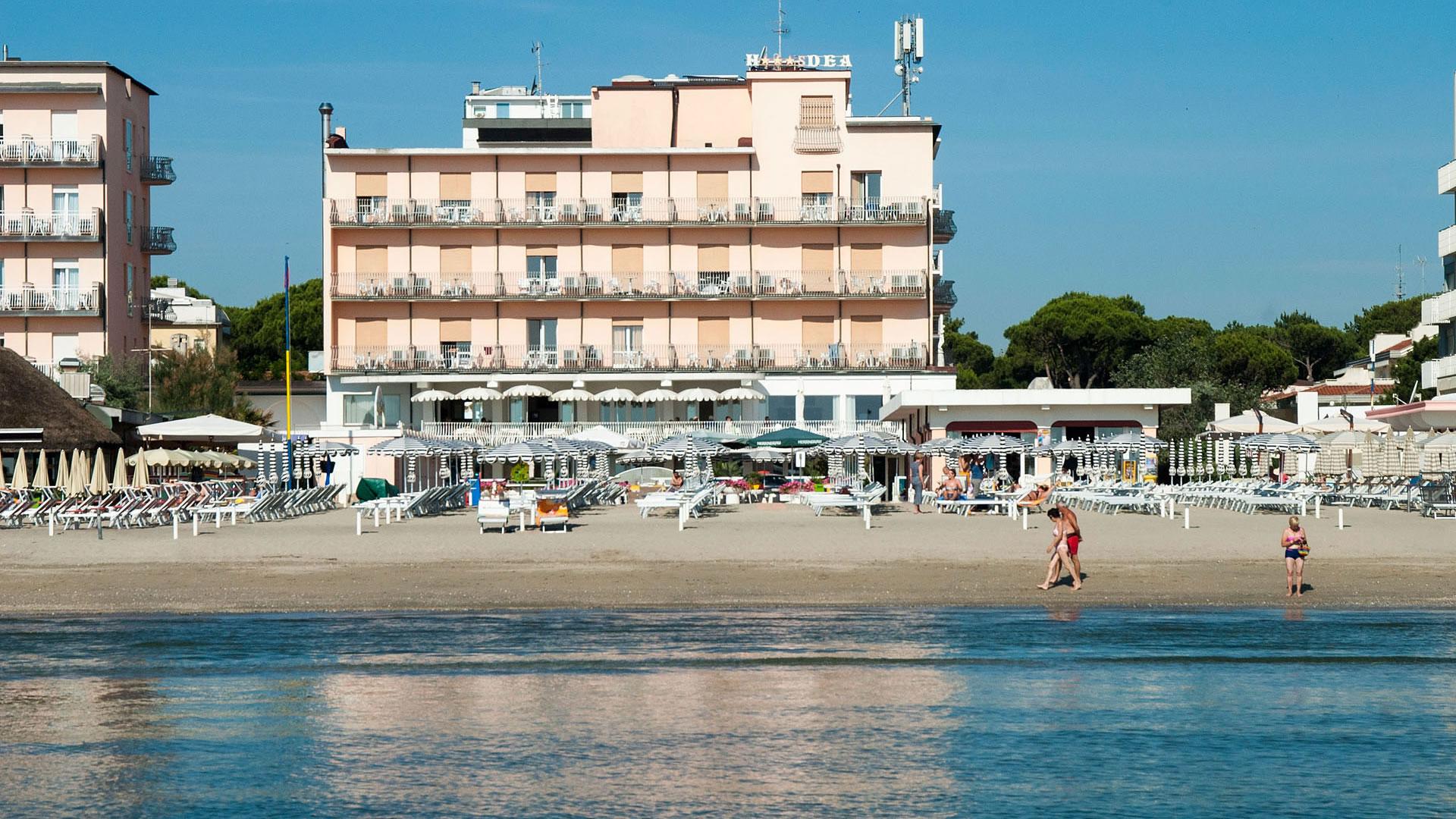 Hôtel en bord de mer avec plage équipée et parasols.