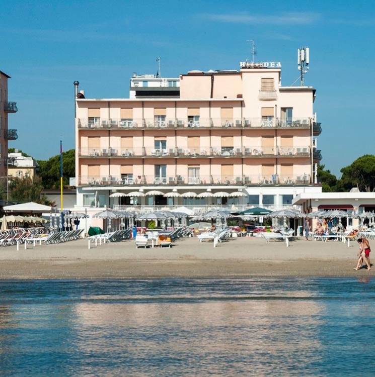 Hotel fronte mare con lettini sulla spiaggia.